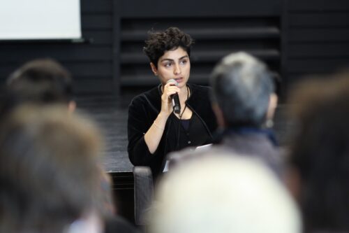 Hoda Siahtiri speaking into a microphone at the On loss and resilience symposium